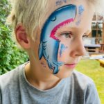 junge_lächelnd_geschminkt_03_haifisch_blau_hellblau_pink_zähne_glitzer