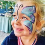 mädchen_lächelnd_geschminkt_07_schmetterling_glitzer_blau_lila